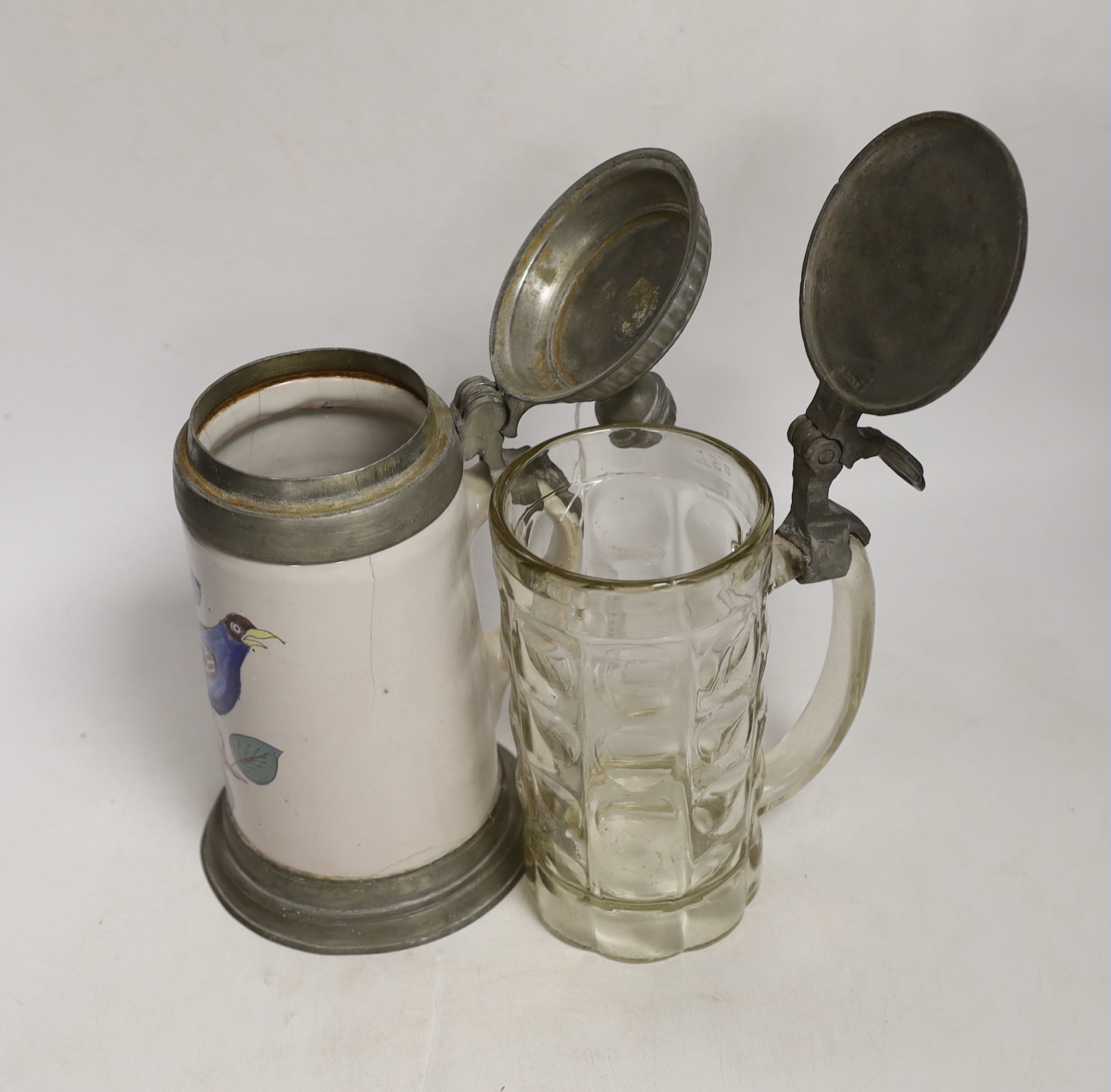 Two German steins including a faience example, together with a glass inkwell, largest 24cm high